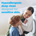 Smiling woman and child with a towel by a washing machine and text about hypoallergenic deep clean