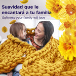 Lifestyle graphic of a mother and child wrapped in a chunky yellow blanket with floral accents and softness messaging