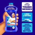 Hand holding a Mr. Clean Ocean bottle against purple background with callouts for tough messes and long-lasting freshness.