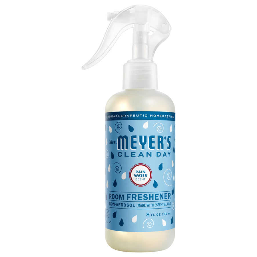 Clear spray bottle of Mrs. Meyer’s Clean Day Rain Water room freshener with blue label and trigger sprayer on white background.
