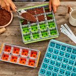 Top-down lifestyle scene showing multiple Burpee SuperSeed trays in different colors being filled with potting mix on a wooden table