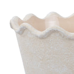 Close-up of the wavy scalloped rim and textured cream surface of a My Texas House ceramic planter