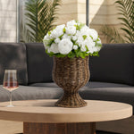 Styled living-room scene with brown woven goblet planter filled with white floral arrangement on a round table