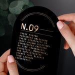 Hands holding an informational oval card titled N.09 with descriptive copy about the perfumers and scent experience