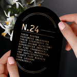 Hands holding a black card labeled N.24 with descriptive copy about master perfumers and elevating the laundry experience