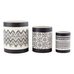 Three Nikos ceramic planters in graduated sizes with black rims and white bodies featuring distinct black patterns.