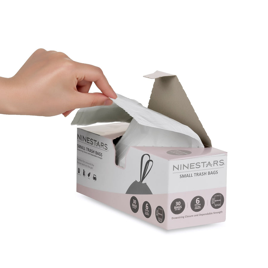 Hand pulling a white drawstring trash bag from a Ninestars small trash bag dispensing box on white background