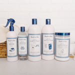 Row of Noodle & Boo laundry care products including Ultra-Soft Fabric Conditioner arranged on a shelf against a white brick wall