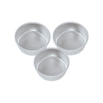 Three silver Nordic Ware natural aluminum round cake pans arranged on white background, brand stamp visible