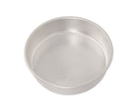 Nordic Ware aluminum 9-inch round cake pan photographed at an angle on white background, showing interior and rim.