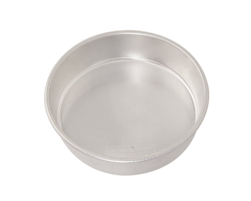 Nordic Ware aluminum 9-inch round cake pan photographed at an angle on white background, showing interior and rim.