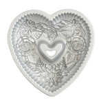 Silver Nordic Ware floral heart bundt pan, top view showing embossed flower and leaf details and heart-shaped center tube.