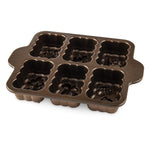 Nordic Ware six-cavity mini loaf pan angled to show molded harvest designs inside each cavity
