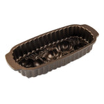 Interior view of dark bronze decorative loaf pan showing detailed pumpkin and wheat relief and fluted sides