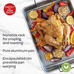 Roasted whole chicken and vegetables on a black crisping rack inside an aluminum roasting pan with product text overlay