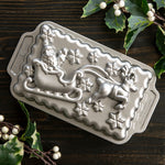 Nordic Ware detailed cast-aluminum loaf pan featuring Santa in a sleigh pulled by a reindeer with snowflakes