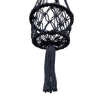 Underneath view of round black macramé planter hanger highlighting circular woven base and hanging tassel