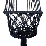 Close-up of black macramé lattice planter basket showing woven diamond pattern and tassel below