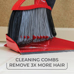 Close-up of red dustpan and broom bristles with built-in cleaning combs removing hair and debris from the dustpan