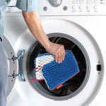 Hand placing O-Cedar microfiber mop head into front-loading washing machine for cleaning