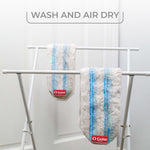 Two O-Cedar microfiber mop pads hanging on a drying rack with visible brand tags and text about air drying