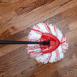 Overhead view of an O-Cedar red triangular mop head and white-and-red refill mop on a hardwood floor