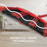 Close-up angled view of O-Cedar red and black broom bristles with white graphic line and blurred living room background