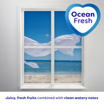 Ocean view through a window with billowing white fabric and a heart badge reading 'Ocean Fresh' above a scent description