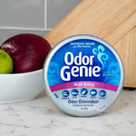 Odor Genie Wild Berry canister displayed on a kitchen counter next to a bowl with an onion and lime
