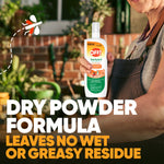 Hand holding an OFF! Backyard FamilyCare spray bottle in a garden setting with text about dry powder formula and no greasy residue
