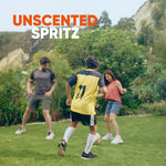 Three people playing soccer on a lawn with headline text 'Unscented Spritz' over the scene
