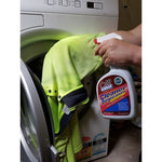 Oil Eater Cleaner Degreaser bottle held beside a front-loading washing machine and a high-visibility garment