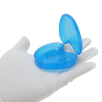 Open translucent blue heart-shaped plastic retainer case displayed on a white-gloved hand against a white background.