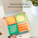 Open box showing four colorful Cocofloss refill boxes arranged in a grid with text inviting exploration of scents