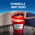 Cutter candle with lid being lifted to reveal the lit interior under 'citronella & mint scent' text