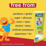 Bright graphic listing product free-from claims with an illustrated orange character and a tube of Orajel Naturals Ms. Rachel toothpaste