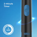 Close-up of a black Oral-B electric toothbrush handle showing power button and 2-minute timer icon on blue background