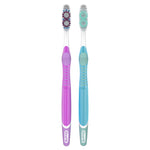 Two Oral‑B manual toothbrushes side by side with purple and teal handles and patterned multicolored bristle tufts