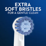 Closeup of an Oral‑B sensitive round brush head showing extra soft blue bristles against a dark blue background. 
