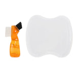 Orange dual-head denture-cleaning brush beside the white top of a curved plastic denture storage case on a white background