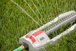 Orbit oscillating sprinkler spraying multiple streams of water over green lawn, close detail