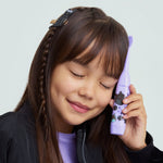 Child holding a purple Ordo Sonic Kids toothbrush with Squishmallows Emily design against a pale background