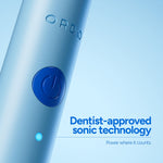 Close-up of light-blue Ordo toothbrush handle showing embossed ORDO logo and power button with caption text