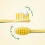 Close-up of a slim yellow toothbrush head with soft bristles and a dollop of toothpaste, labeled soft bristles