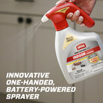 Hand-held Ortho Home Defense Max bottle with red battery-powered sprayer spraying a fine mist in a kitchen setting