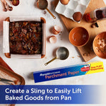 Overhead scene of a baking setup with a square pan lined with Reynolds Kitchens parchment paper and the product box on the counter