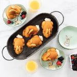 Overhead table setting with four bunny-shaped cakes in a serving dish and two on decorated plates