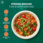 Overhead view of a white compostable bowl filled with colorful vegetable soup and icons listing heavy duty, microwave safe features