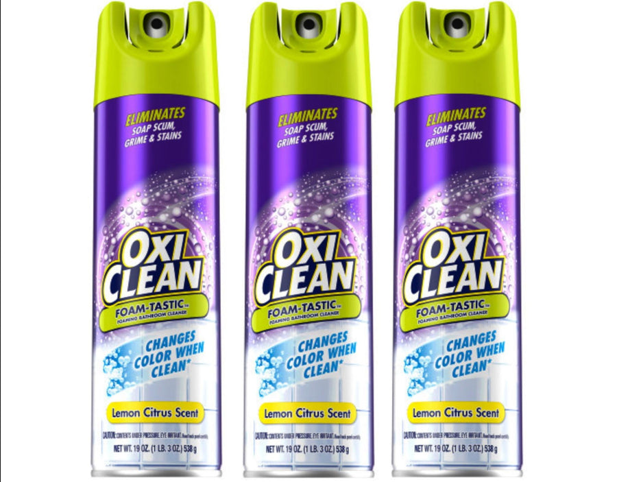 Three OxiClean Foam-Tastic foaming bathroom cleaner spray cans with purple labels and green caps