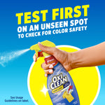Hand holding an OxiClean spray bottle and spraying with headline 'Test first on an unseen spot'